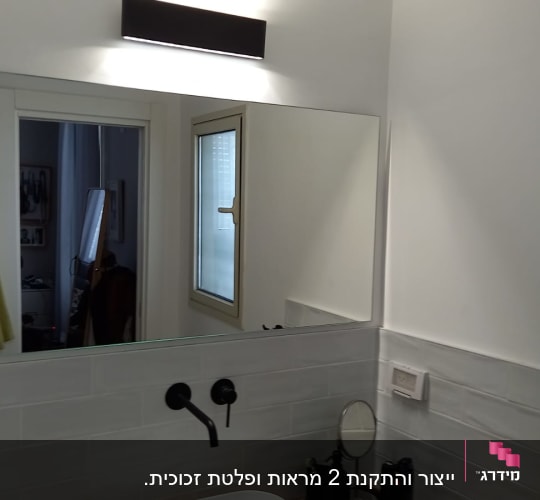 מראה גדולה מעל כיור בחדר אמבטיה